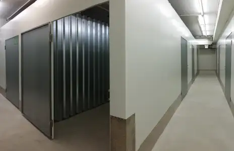 Innenansicht eines Lagerraums bei Miet dein Lager Winnenden: langer Flur mit Metalltüren und Beleuchtung an der Decke.