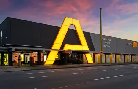Außenansicht von Space Plus Store mit großem leuchtenden A an der Fassade, Beschriftung Self Storage Coworking Flex Office.