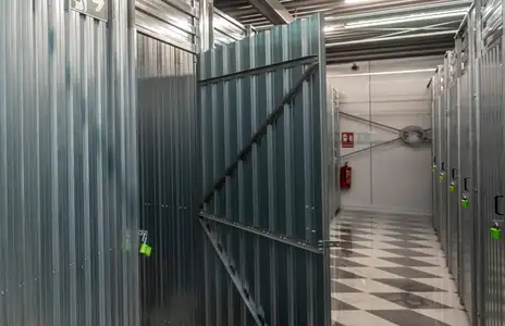 Innenansicht Lagerraum von Storebox; geöffnete Metalltüren, Neonbeleuchtung, schwarz-weiß karierter Boden.