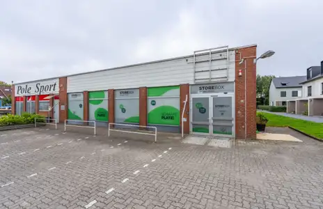 Außenansicht von Storebox in Flensburg mit Parkplatz und Beschriftung am Gebäude.
