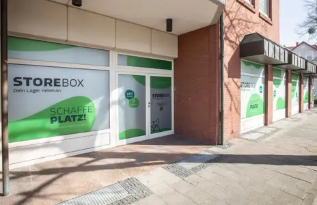 Außenansicht von Storebox in Hameln, Schlachthofstraße. Gebäude mit großer Fensterfront und grüner Beschriftung: Schaffe Platz!.