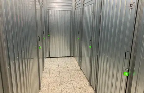 Gang mit Metall-Lagerboxen und grünen Schlössern im Inneren von Storebox Hamm.