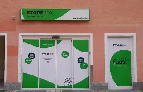 Storebox-Filiale mit grünen und weißen Türen; Beschriftungen für 24/7-Zugang und sichere Lagerung sichtbar.