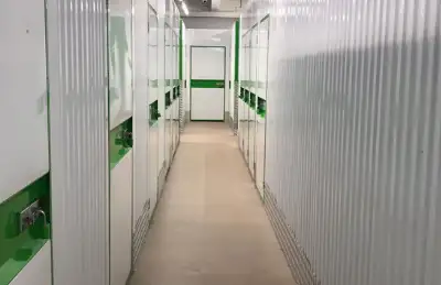 Lagerraum-Gang mit grüner Akzentuierung bei Storebox; weiße Wände und Türen sichtbar, klare Beleuchtung.