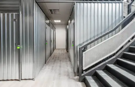 Innenansicht der Storebox in Schwäbisch Gmünd: Metallene Lagerräume und eine Treppe mit Geländer im Vordergrund.