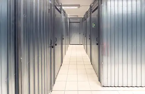 Innenansicht eines Storebox-Lagerraums in Stade mit Metalltüren und gefliestem Boden.