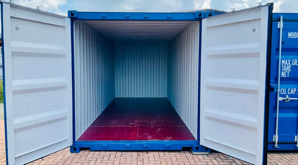 Offener blauer Container auf gepflasterter Fläche bei Lager-Ein DE GmbH Schwülper, Innenraum sichtbar, Türen weit geöffnet.