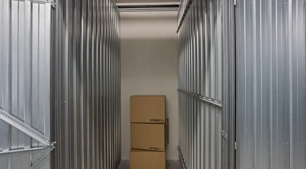 Innenansicht eines Lagerraums von Storebox mit zwei gestapelten Kartons in einem schmalen, metallischen Gang.